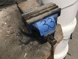 a clamp sitting on top of a table next to a bucket