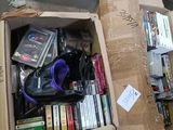 a cardboard box full of books and dvds on the floor