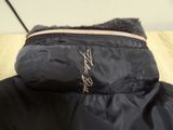the jacket is black and has a pink zipper on it