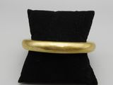 un gros plan d'une bague en or posée sur un coussin noir