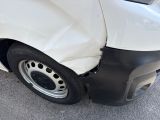 a white van that has been damaged and is parked on the street