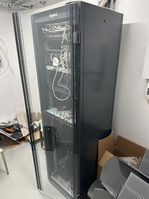 a black cabinet with a glass door in the middle of a room
