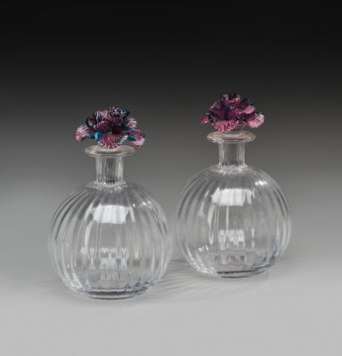 une paire de vases en verre transparent surmontés de fleurs violettes