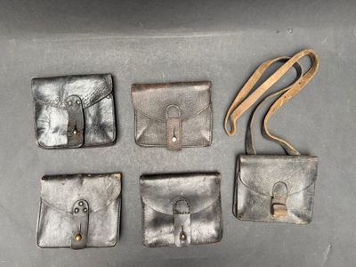 Quatre portefeuilles en cuir sont posés sur une table