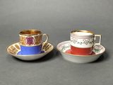 two cups and saucers are sitting side by side on a table