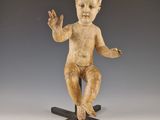 statue d'un bébé assis au sommet d'une croix en bois