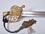 a close up of a sword on a white surface with a tassel