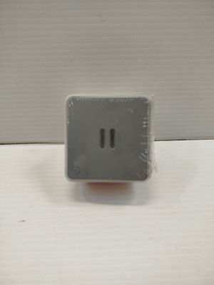 une petite prise électrique grise sur un mur blanc