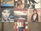 many different album covers on the wall of a room