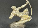 bronze statue of a woman with a bow and arrow on top of a coin