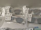 several pairs of sunglasses are wrapped in plastic bags on a table