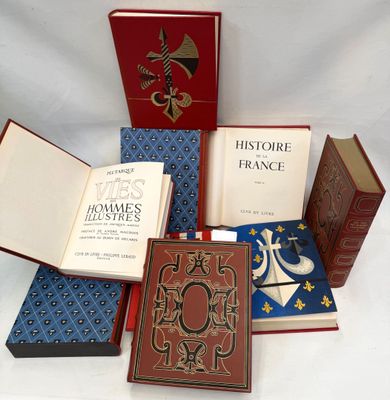 several books are stacked on top of each other on a white surface