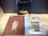 trois livres posés sur une table sur laquelle se trouve un vase