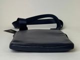 the small black purse is sitting on a white surface