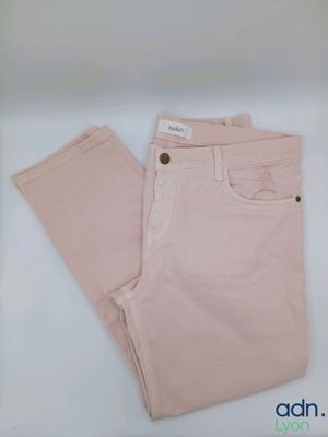 Le pantalon est rose et comporte des boutons.