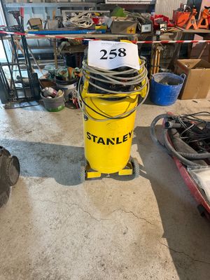 un seau jaune sur lequel est accrochée une pancarte, dans un garage