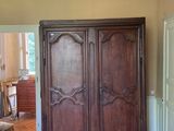 a large wooden armoire in the middle of a room