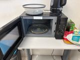a microwave with a bowl on top of it next to a microwave oven