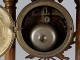 a close up of a clock with a bell on it