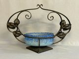 a blue bowl sitting on top of a metal stand