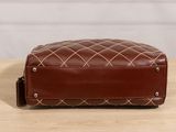 a brown leather toilet bag sitting on top of a wooden table