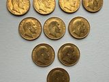 a close up of a bunch of gold coins on a white surface