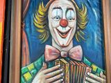 painting of a clown playing an accordion in front of a painting of a clown playing an accordion