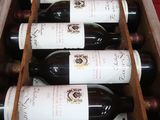 des bouteilles de vin sont disposées dans une caisse en bois sur un fond rouge