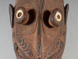 l'image d'un masque en bois comportant deux yeux sur un fond blanc