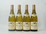 quatre bouteilles de vin sont alignées sur une surface blanche
