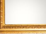 a gold framed mirror on the wall with a white background