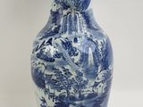 un vase bleu et blanc posé sur une surface blanche