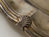 a silver plate with a spoon on it on a table