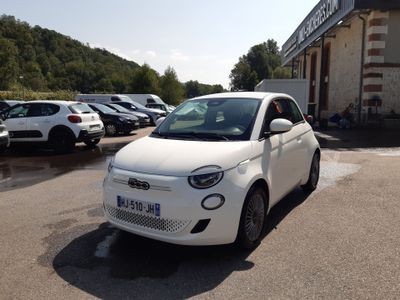 une petite voiture blanche garée devant un bâtiment
