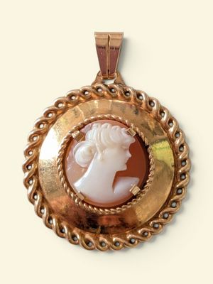an image of a picture of a woman ' s face in a gold pendant