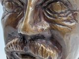 a bronze statue of a man with a mustache and moustache