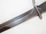 a close up of a knife on a white surface