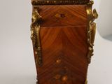 a small wooden box with a gold decoration on it