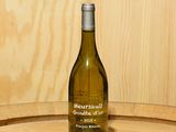 une bouteille de vin posée sur un tonneau