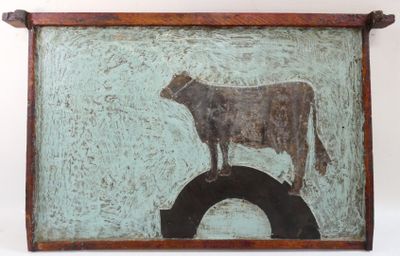 a painting of a cow standing on top of a tire