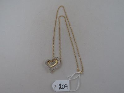a close up of a gold necklace with a heart on it