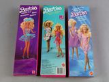 three barbie dolls are lined up in a row on a table