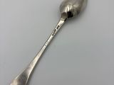 an old silver spoon with a spoon handle on a white surface