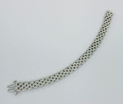 gros plan d'un bracelet en chaîne en argent sur une surface blanche