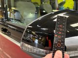 a person holding a measuring tape in front of a car