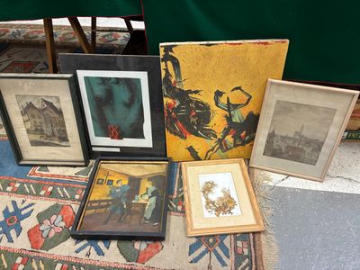 de nombreux tableaux encadrés posés par terre à côté d'un tapis