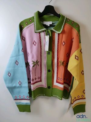 a colorful sweater hanging on a hanger on a wall