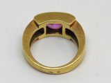 une image d'une bague en or avec une pierre rose au centre