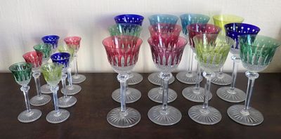 many different colored wine glasses lined up on a table