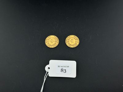 a pair of gold coins with a price tag on a black surface
